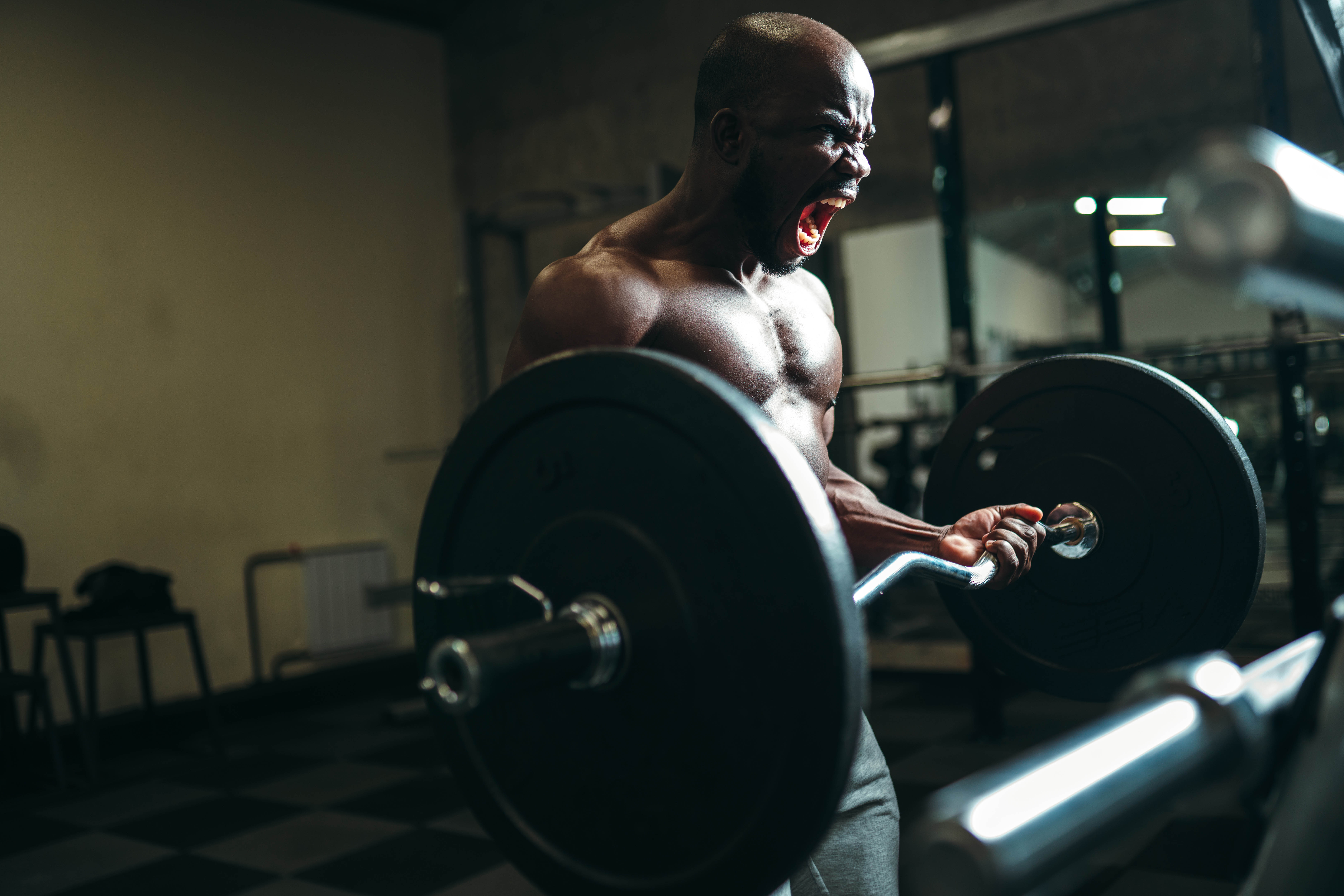 Muscular man doing a deadlift and yelling Muscular man doing a deadlift and yelling